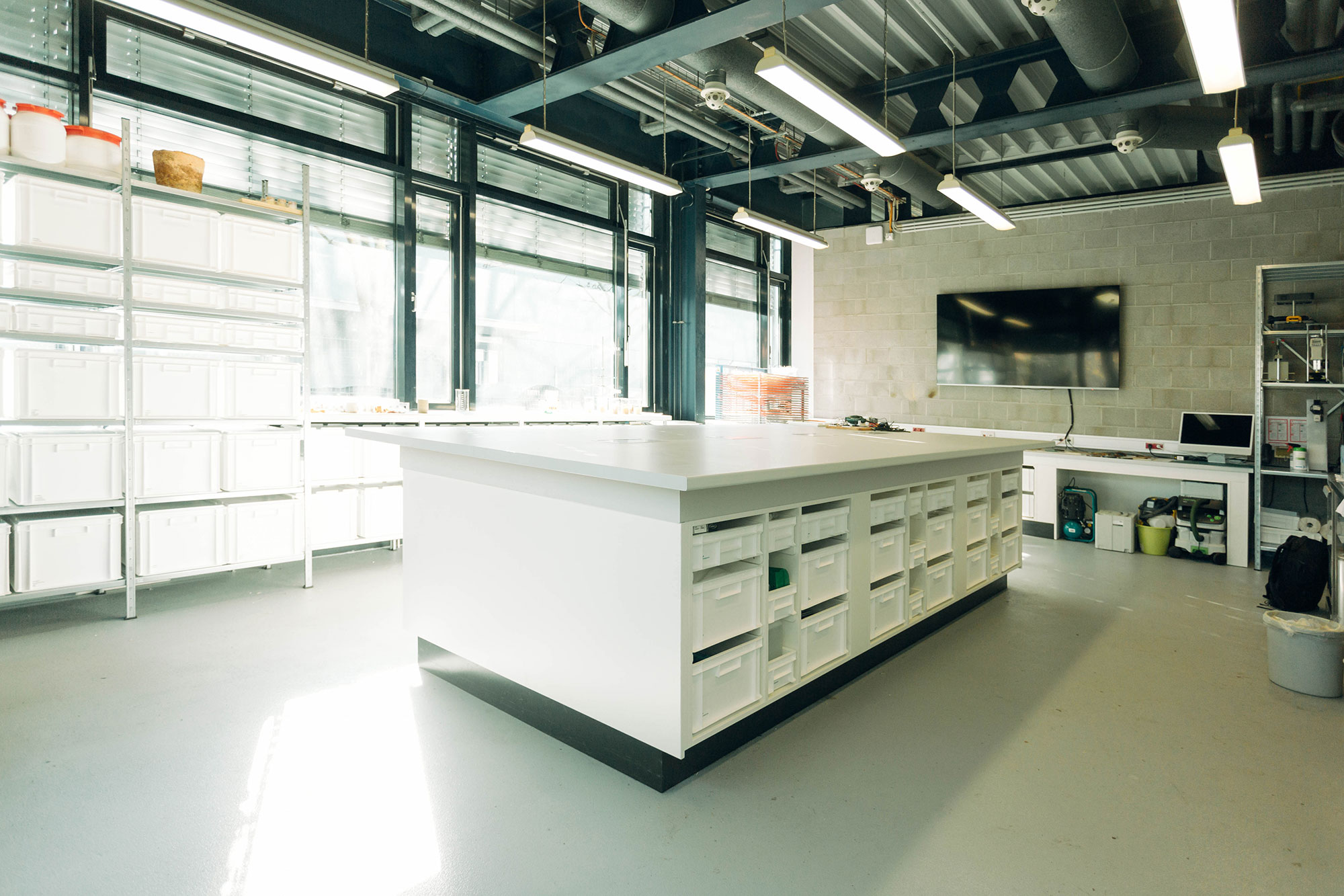 Weißer großer Tisch mit Schubladen in Labor mit technischen Geräten